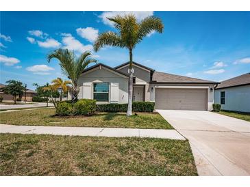 Charming single-story home featuring a well-manicured lawn and a two car garage at 7202 Ozello Trail Ave, Ruskin, FL 33573