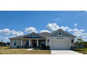 Charming one-story home with blue and gray exterior paint and well-manicured lawn at 4294 Cork Rd, Plant City, FL 33565