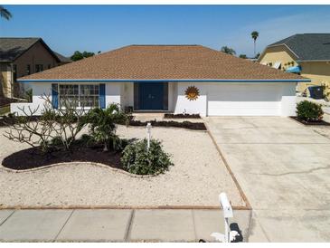 Charming single-story home boasts a well-maintained yard with decorative landscaping and a two-car garage at 6528 Santiago Ct, Apollo Beach, FL 33572