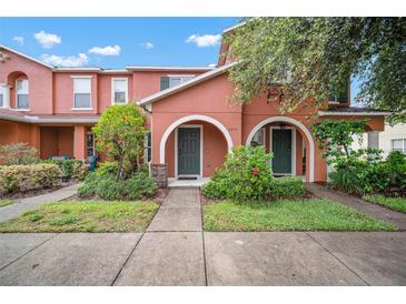 Charming townhome with lovely landscaping, sidewalk and covered entrances with beautiful arches and green doors at 6831 Dartmouth Hill St, Riverview, FL 33578