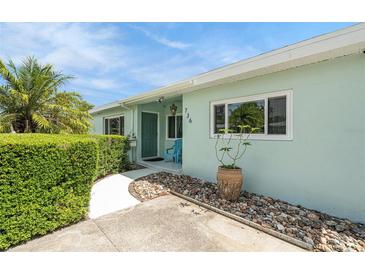 Front entrance featuring fresh paint, decorative rock, and manicured hedges at 736 85Th N Ave, St Petersburg, FL 33702