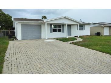 Charming single-story home featuring a brick driveway and attached one car garage at 10817 Fillmore Ave, Port Richey, FL 34668