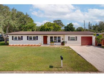 Charming single-story home featuring a well-maintained lawn, neutral paint, and a neatly manicured landscape at 1644 Scott St, Clearwater, FL 33755