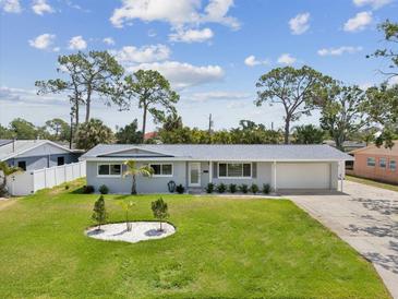 Charming single-story home with a manicured front lawn and a spacious driveway leading to an attached garage at 4501 Huntington Ne St, St Petersburg, FL 33703