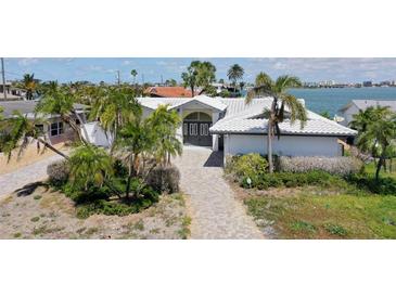 An aerial view showing the front facade, lush palm trees, and waterway location at 511 64Th Ave, St Pete Beach, FL 33706