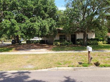 Charming single-story home featuring mature trees, lush landscaping, and a welcoming front lawn at 601 Park Blvd, Oldsmar, FL 34677