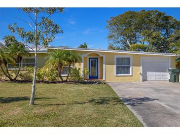 Charming single-story home with a well-manicured lawn and blue front door entrance at 12384 144Th St, Largo, FL 33774