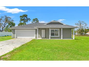 Charming single-story home featuring a well-manicured lawn and attached two-car garage at 13193 Paxton Ave, Weeki Wachee, FL 34614