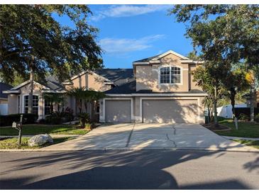 Charming two-story home featuring a three-car garage, landscaped front yard, and a well-maintained driveway at 19116 Nature Palm Ln, Tampa, FL 33647