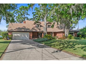Charming brick home featuring a well-manicured lawn, mature trees, and a spacious driveway at 19254 Blount Rd, Lutz, FL 33558