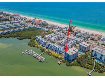 Stunning aerial view of waterfront condo with beach access and boat dock, offering luxury coastal living at 19925 Gulf Blvd # 503, Indian Shores, FL 33785
