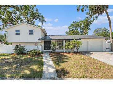 Charming two-story home with a well-manicured lawn and an attached two car garage at 8302 W Pocahontas Ave, Tampa, FL 33615