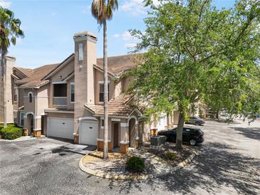 Charming townhome features a tile roof, an attached garage, and well-maintained landscaping at 10434 Villa View Cir, Tampa, FL 33647