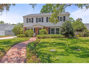 Charming two-story home with manicured lawn and inviting brick pathway at 1211 S Druid Ln, Tampa, FL 33629