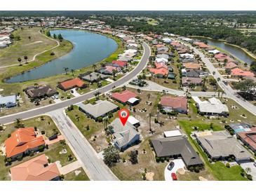 An aerial view of the neighborhood shows homes with mature landscaping, and close proximity to a large lake at 2004 Berry Roberts Dr, Sun City Center, FL 33573