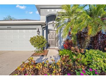 Charming home with a well-maintained lawn and colorful garden beds, showcasing its welcoming curb appeal at 20203 Merry Oak Ave, Tampa, FL 33647