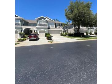 Inviting townhome with a well-maintained lawn, driveway, and two car garage under a clear blue sky at 2111 Park Crescent Dr, Land O Lakes, FL 34639