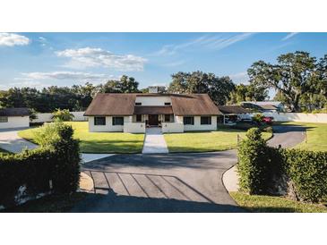 Charming home featuring lush landscaping, a circular driveway, and a welcoming front entrance at 2780 E Sam Allen Rd, Plant City, FL 33565