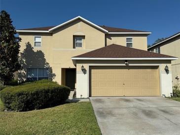 Two-story home featuring a two-car garage, well-manicured lawn, and neat shrubbery at 32111 Brookstone Dr, Wesley Chapel, FL 33545
