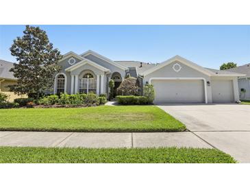 Charming single-story home with a well-manicured lawn and a three-car garage at 5119 Whispering Leaf Trail, Valrico, FL 33596