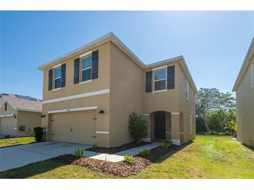 Beautiful two-story home with a two-car garage, an inviting front porch and manicured landscaping at 16810 Trite Bend St, Wimauma, FL 33598
