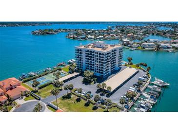 Stunning aerial view of a waterfront condo community with boat docks, tennis courts, and lush landscaping at 240 Sand Key Estates Dr # 58, Clearwater Beach, FL 33767