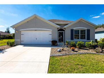 Charming single-story home with a well-maintained lawn, a two-car garage and neutral color scheme at 25317 E Lenox Cir, Punta Gorda, FL 33950