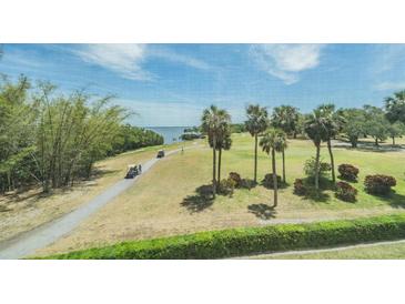 Scenic golf course view with lush greens, palm trees, and blue waters in the background at 2616 Cove Cay Dr # 301, Clearwater, FL 33760
