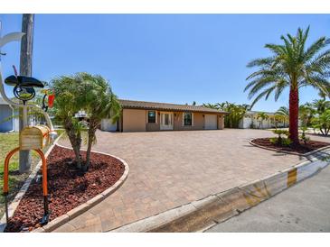 Stunning single-story home features a paver driveway, lush landscaping, and a well-maintained lawn at 4011 99Th W St, Bradenton, FL 34210