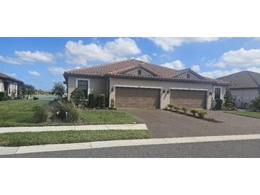 Charming home with two-car garage, landscaped lawn, and brick driveway on a sunny day at 5406 Rushmere Ct, Palmetto, FL 34221