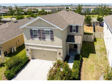 Two-story home featuring a two-car garage, manicured lawn, and neutral stucco exterior at 7486 Tuscan Bay Cir, Wesley Chapel, FL 33545