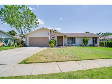 Charming single-story home with stone accents, a well-manicured lawn and an attached two car garage at 1104 Northridge Dr, Palm Harbor, FL 34683