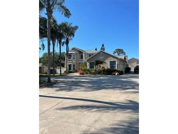 Inviting two-story home featuring lush landscaping and mature palm trees in a desirable neighborhood at 13211 Park Blvd, Seminole, FL 33776