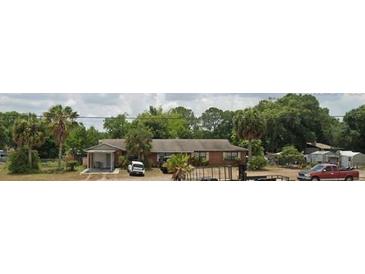 Charming single-story home with a cozy carport and a lush, green yard filled with mature trees at 17026 State Road 54, Lutz, FL 33558