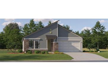 Modern single-Gathering home with stone accents, gray siding, an attached garage, and manicured front lawn at 18452 Serene Lake Loop, Lutz, FL 33548