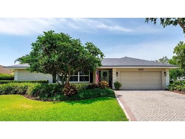 Charming single-story home featuring a well-manicured lawn, mature landscaping, and a brick driveway at 500 Tallahassee Ne Dr, St Petersburg, FL 33702