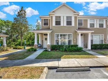 Charming townhome featuring a welcoming front porch, lush landscaping and neutral colored siding at 11041 Black Swan Ct, Seffner, FL 33584