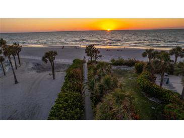 Beautiful sunset view of the beach with palm trees and white sand at 1581 Gulf Blvd # 301N, Clearwater Beach, FL 33767