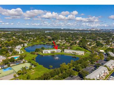 Aerial shot of waterfront townhomes with a community pool, tennis courts, and lake views at 4816 Snook Se Dr # F, St Petersburg, FL 33705