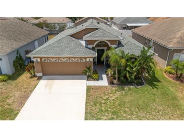 Charming, single-story home boasts a well-manicured lawn, mature landscaping, and an attached two-car garage at 518 Greg St, Valrico, FL 33594