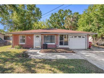 Charming brick home featuring a well-kept front yard and an attached single-car garage at 705 E Alabama St, Plant City, FL 33563