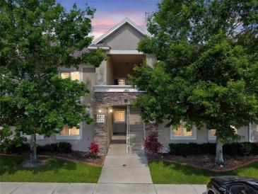 Charming two-story condo building featuring manicured landscaping and stone accents for a welcoming curb appeal at 1231 Godavari Way # 103, Wesley Chapel, FL 33543