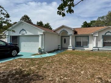 Charming single-story home with a well-maintained lawn, attached garage, and neutral paint scheme at 12447 Drysdale St, Spring Hill, FL 34609