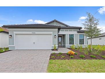 Charming single-story home with a two-car garage, landscaped yard, and a welcoming front entrance at 17200 Luminous Ave, Venice, FL 34293