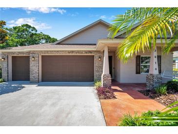 Inviting home with a brick-accented facade, a three-car garage, and a charming front porch at 3610 Montero Ct, Sun City Center, FL 33573