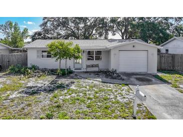Charming single-story home featuring a well-maintained lawn and attached one car garage at 1408 Maybury Dr, Holiday, FL 34691