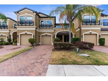 Charming townhome featuring a brick drive, two-car garage, and well-maintained landscaping at 1969 Milkweed Trce, Lutz, FL 33558