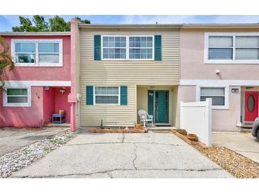 Charming townhouse featuring colorful exteriors, green shutters, and a welcoming front porch at 2811 S Pines Dr # 15, Largo, FL 33771