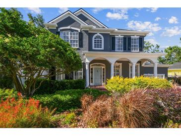 Charming two-story home with lush landscaping and a welcoming front porch with white columns at 3311 Home Ct, Tampa, FL 33611
