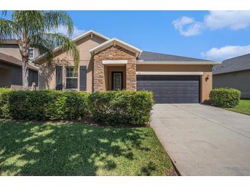 Charming single-Gathering home featuring desert landscaping, a two-car garage, and a stone-accented entryway at 4145 Shrewbury Pl, Land O Lakes, FL 34638